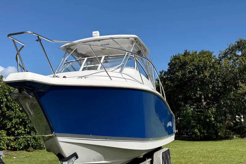 Slide: The Image of 2007 Pro-Line 32 Express boat with blue hull on trailer, set against a clear sky. - 9