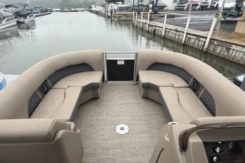 Slide: The Image of 2024 Bennington 22LSR pontoon boat with spacious seating, docked at a marina. - 7