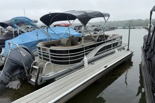 The Image of 2024 Bennington 22LSR pontoon boat docked at a marina on a cloudy day. - 1