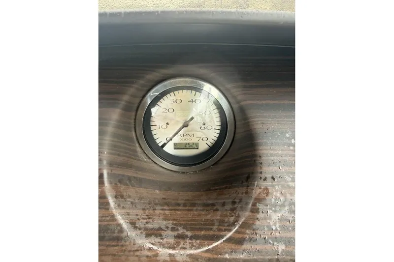 Slide: The Image of Close-up of a 2024 Bennington 22LSR RPM gauge on a wooden dashboard. - 12