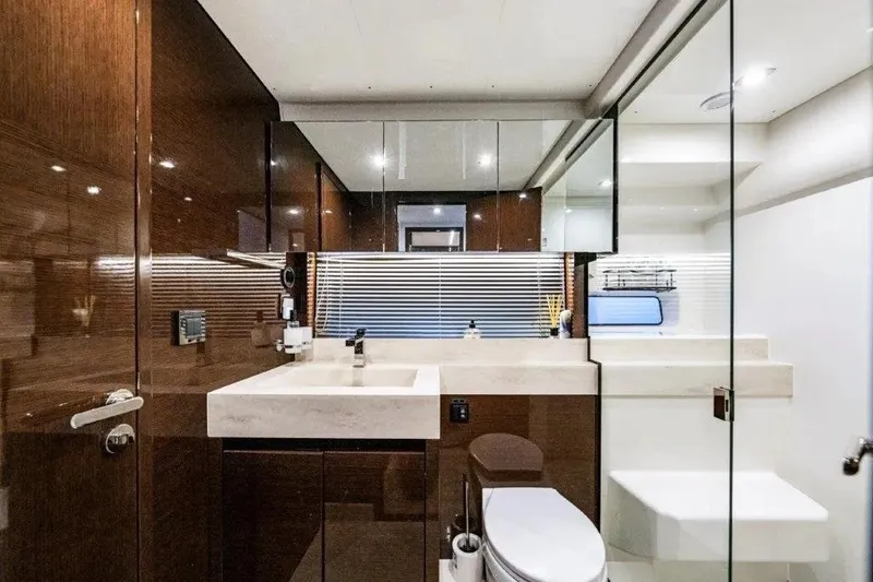 Slide: The Image of Luxurious 2020 Prestige 590 yacht bathroom with modern fixtures and elegant wood finishes. - 25