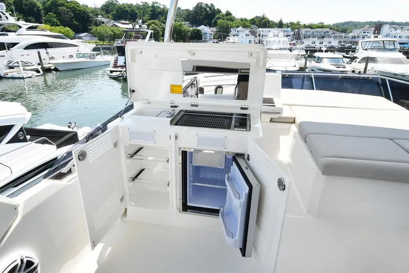 Slide: The Image of Outdoor kitchen on 2020 Prestige 590 yacht with grill and fridge, docked at marina. - 42