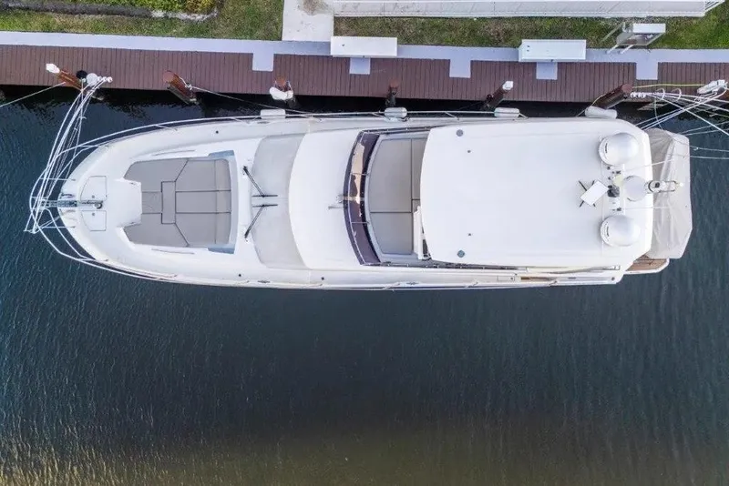 Slide: The Image of Aerial view of a 2020 Prestige 590 yacht docked by the water. - 2