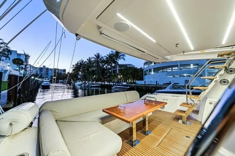 Slide: The Image of Luxurious 2020 Prestige 590 yacht interior with elegant seating and wooden table at sunset. - 6