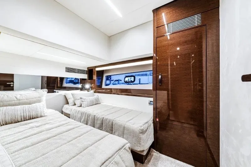 Slide: The Image of Luxurious twin bedroom interior on a 2020 Prestige 590 yacht, featuring elegant wood finishes. - 27