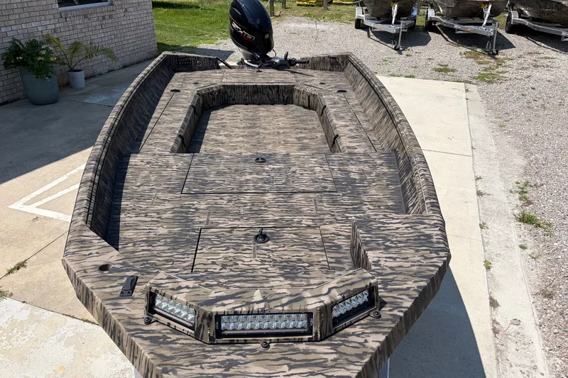 Slide: The Image of 2026 Excel 183 Tomahawk boat with camouflage design and LED lights, parked outdoors. - 8