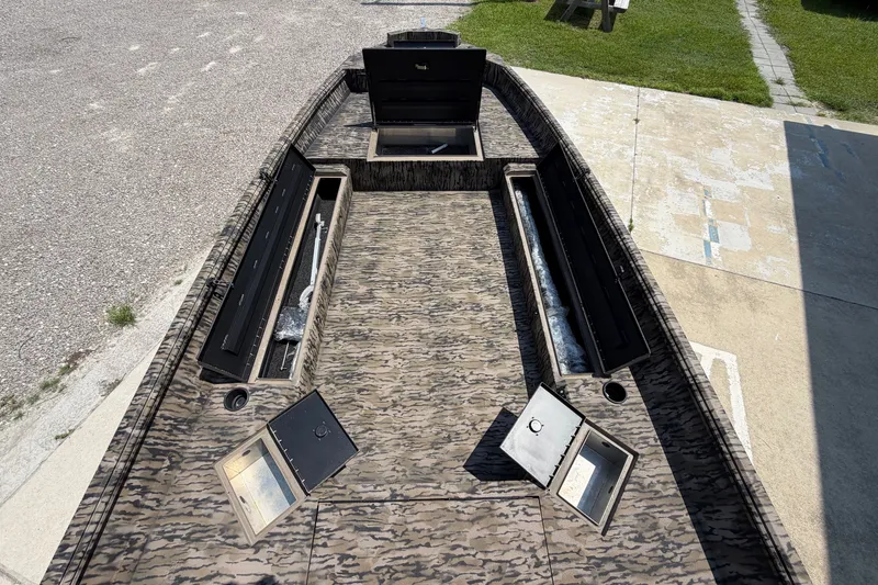 Slide: The Image of 2026 Excel 183 Tomahawk boat interior with open storage compartments on a sunny day. - 11