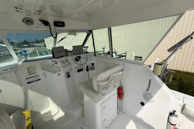 Slide: The Image of 2006 Baha Cruiser 299 SF boat cockpit with steering wheel, navigation equipment, and seating. - 10