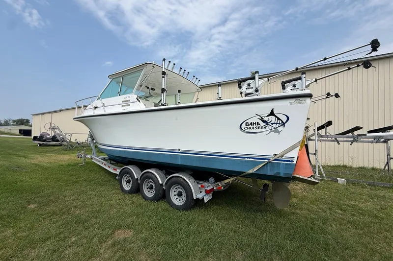 Slide: The Image of 2006 Baha Cruiser 299 SF boat on trailer, parked on grass near a building. - 2