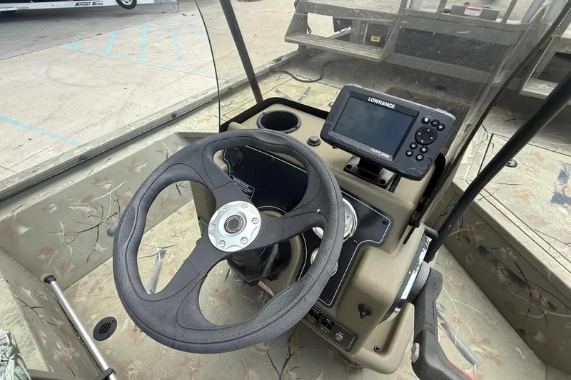 Slide: The Image of 2024 Tracker Grizzly 2072 MVX CC Sportsman boat dashboard with steering wheel and Lowrance display. - 15