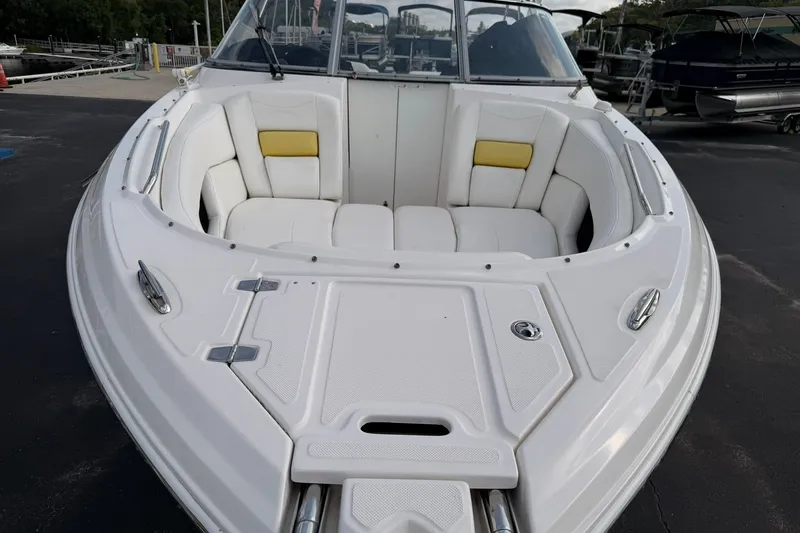 Slide: The Image of 2007 Regal 2700 Bowrider boat with white seating and yellow accents, docked at marina. - 22