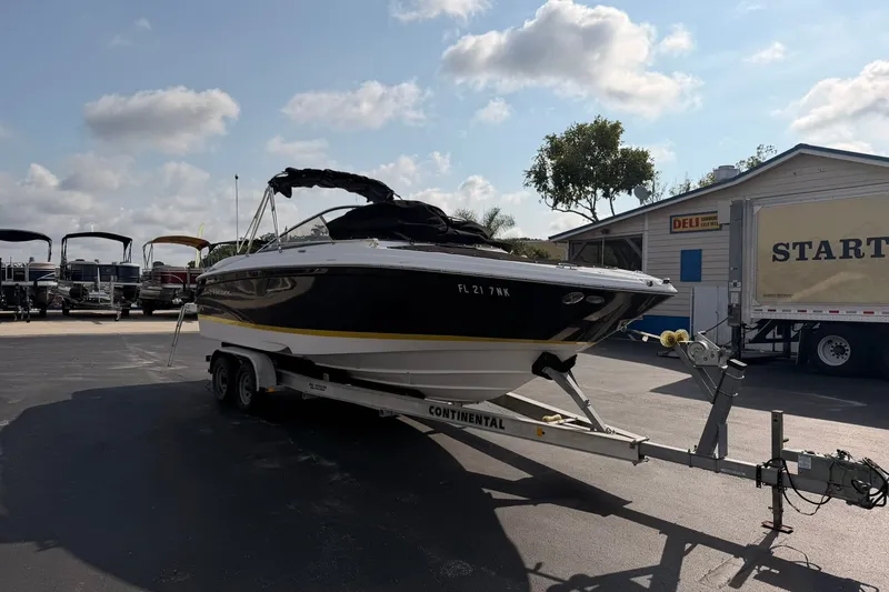 Slide: The Image of 2007 Regal 2700 Bowrider boat on trailer, parked outdoors under a partly cloudy sky. - 4