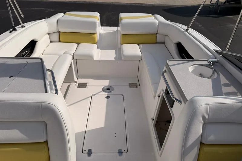 Slide: The Image of 2007 Regal 2700 Bowrider interior with white and yellow seating, sink, and storage. - 13