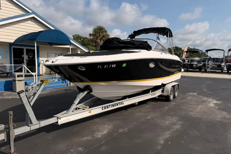 Slide: The Image of 2007 Regal 2700 Bowrider boat on trailer, parked outside a building under a blue sky. - 2