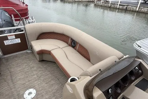 Slide: The Image of 2022 Bennington 22LSR pontoon boat with beige seating, docked by the water. - 7
