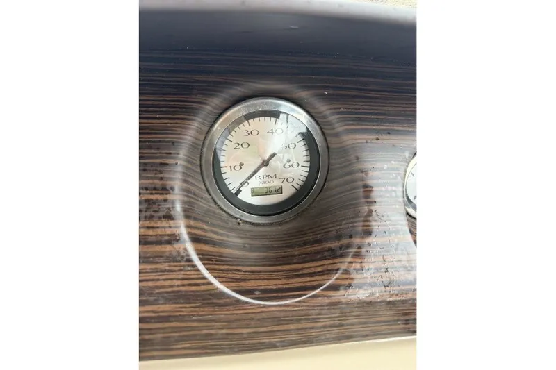 Slide: The Image of Close-up of a 2022 Bennington 22LSR RPM gauge on a wood-textured dashboard. - 9