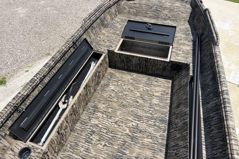 Slide: The Image of 2026 Excel 1651 River Warrior boat interior with storage compartments and camouflage design. - 10