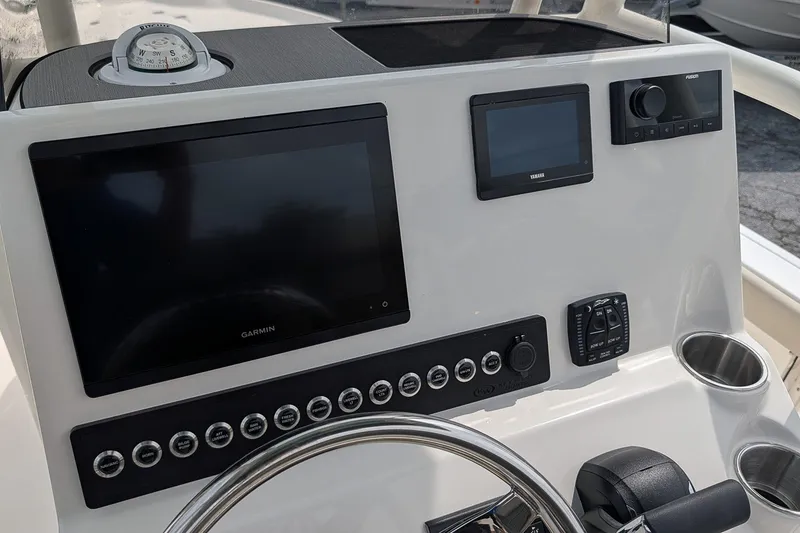 Slide: The Image of 2027 Key West 250 Bay Reef dashboard with Garmin display and controls. - 18