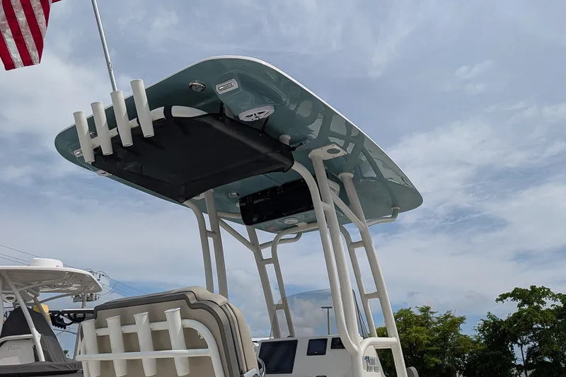 Slide: The Image of 2027 Key West 250 Bay Reef boat with T-top and rod holders under a cloudy sky. - 25