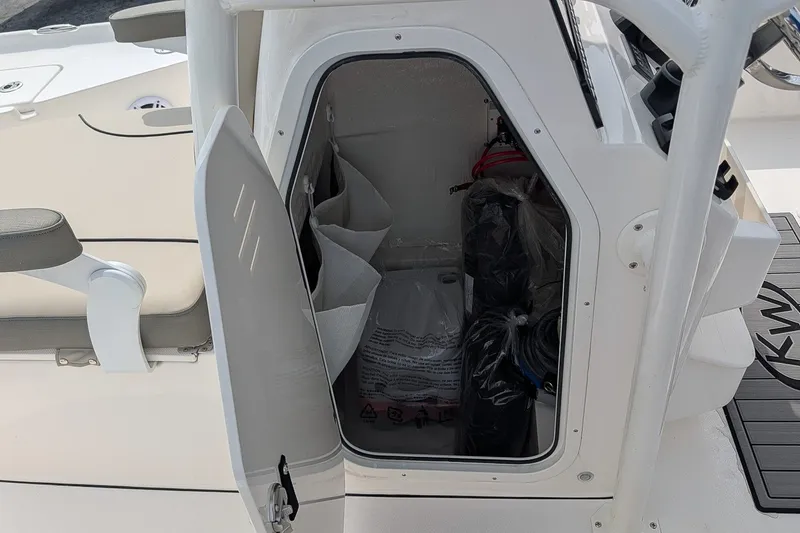 Slide: The Image of Open storage compartment on 2027 Key West 250 Bay Reef boat, showing interior contents. - 19