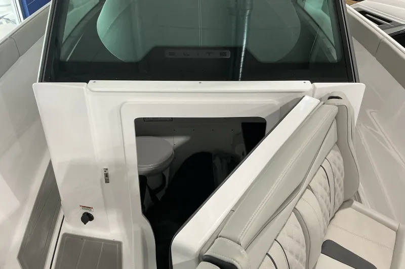 Slide: The Image of 2027 Monterey Elite 27 SD boat interior with open cabin door revealing a compact toilet. - 12