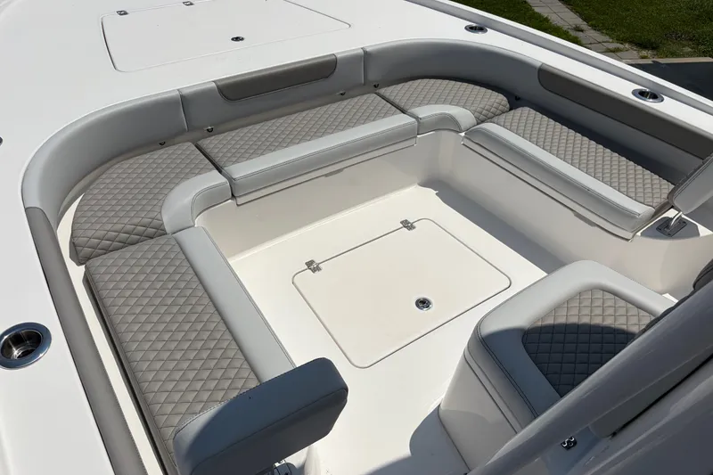 Slide: The Image of The image shows the seating area of a Caymas 28 HB boat with cushioned seats and storage. - 15