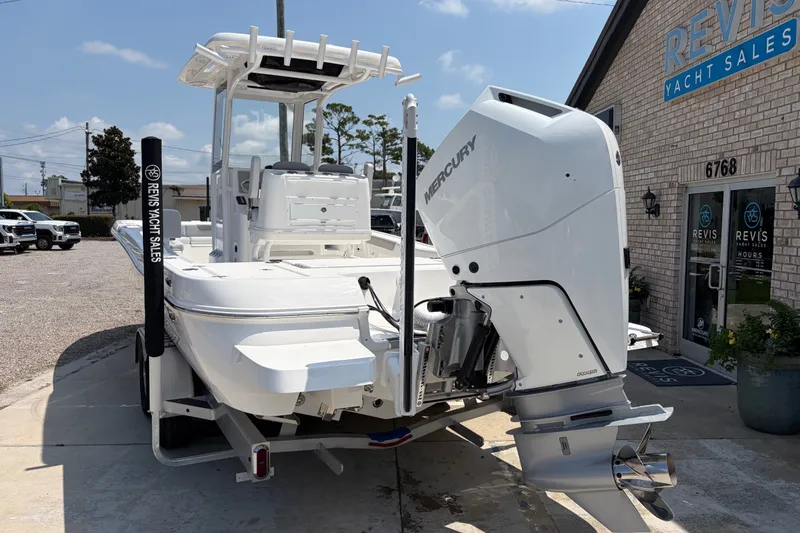 Slide: The Image of A 2026 Caymas 28 HB boat with a Mercury outboard motor, parked outside a yacht dealership. - 3