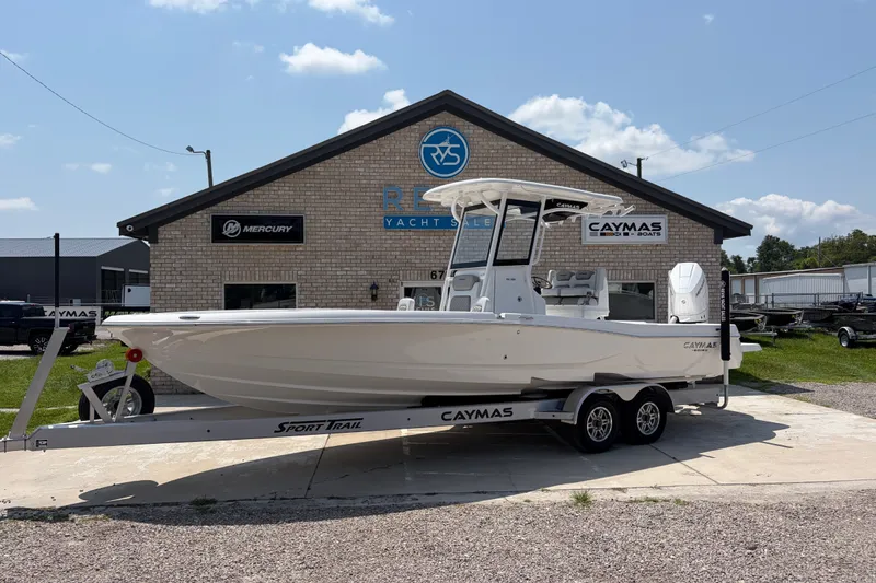 The Image of A white 2026 Caymas 28 HB boat on a trailer in front of a building. - 1