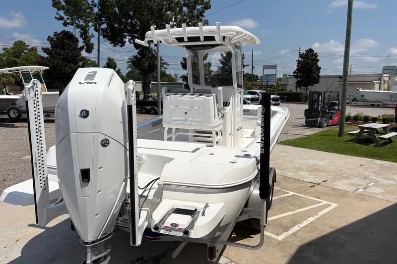 Slide: The Image of A white 2026 Caymas 28 HB boat is parked on a lot. It features a large outboard motor and elevated helm. - 4