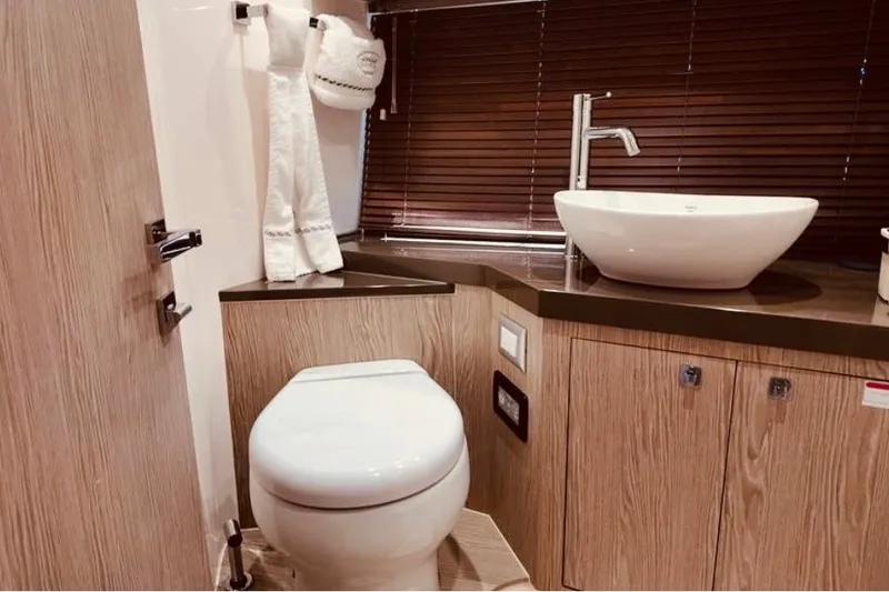 Slide: The Image of Luxurious bathroom in 2024 Sessa Marine C44 Cruiser with modern fixtures and wooden cabinetry. - 4