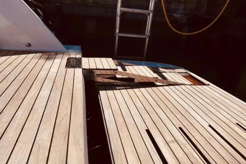 Slide: The Image of Teak deck of 2024 Sessa Marine C44 Cruiser with ladder in background. - 8