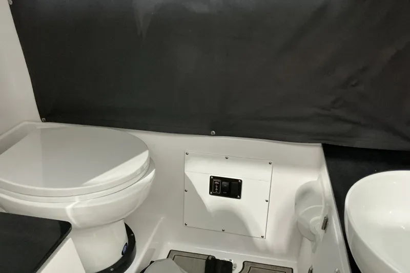 Slide: The Image of Interior of 2027 Monterey Elite 25 SD boat bathroom with toilet and sink. - 18