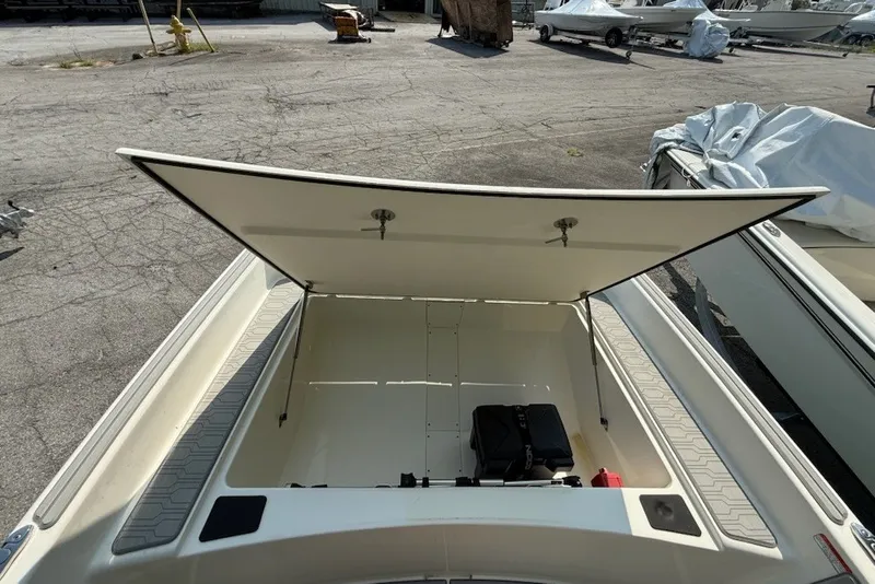 Slide: The Image of 2025 Mako Pro Skiff 17 CC boat storage compartment open, revealing interior space. - 9