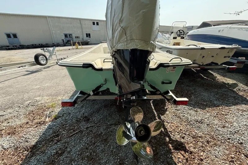 Slide: The Image of 2025 Mako Pro Skiff 17 CC boat with covered motor, parked on gravel. - 12