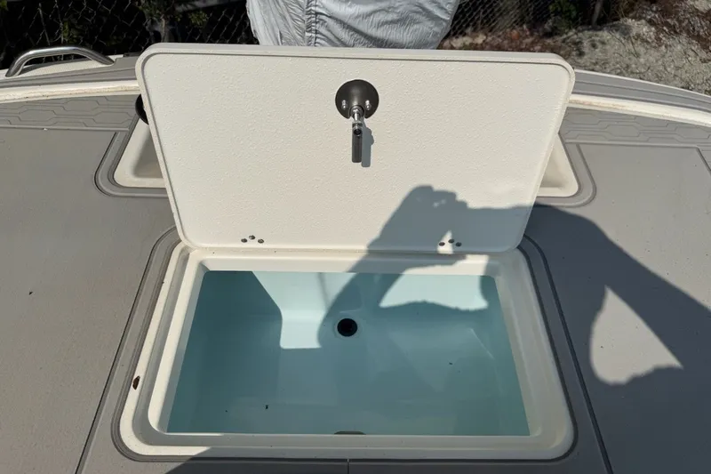 Slide: The Image of Open storage compartment on 2025 Mako Pro Skiff 17 CC boat deck. - 10