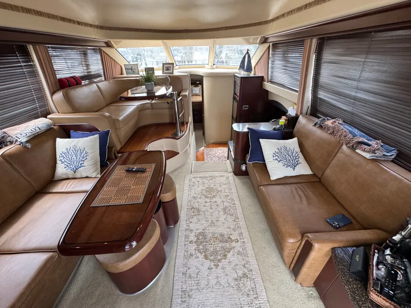 Slide: The Image of Interior of a 2007 Sea Ray 44 Sedan Bridge with elegant leather sofas and wooden table. - 3
