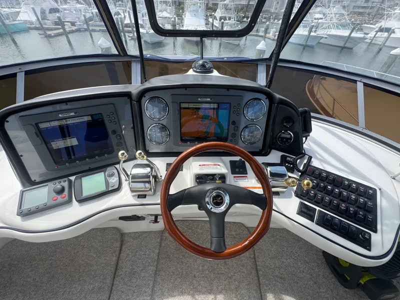 Slide: The Image of Helm of the 2007 Sea Ray 44 Sedan Bridge with modern navigation systems and a wooden steering wheel. - 19