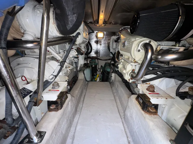 Slide: The Image of The engine room of a 2007 Sea Ray 44 Sedan Bridge features two large engines and piping. - 21