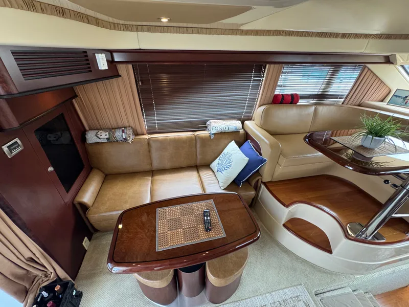 Slide: The Image of Interior of a 2007 Sea Ray 44 Sedan Bridge with leather sofas and a wooden table. - 4