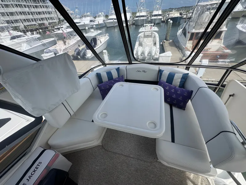 Slide: The Image of The 2007 Sea Ray 44 Sedan Bridge features a cozy flybridge seating area with a table and cushions. - 16