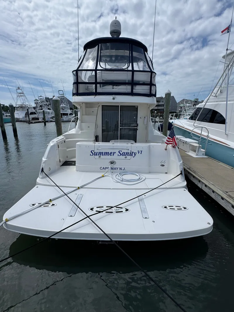 Slide: The Image of A 2007 Sea Ray 44 Sedan Bridge docked. It features a spacious aft deck and flybridge. - 2