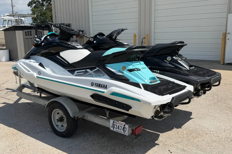 Slide: The Image of 2024 Yamaha Waverunner jet skis on a trailer, parked outdoors near a building. - 4