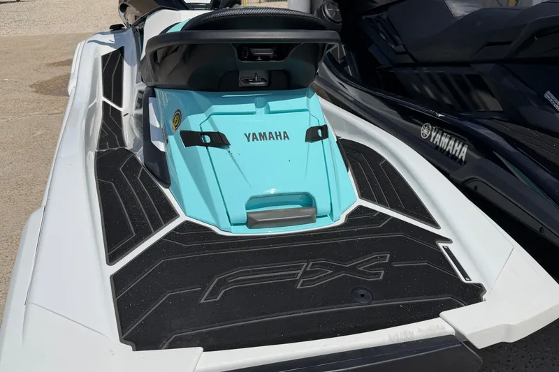 Slide: The Image of 2024 Yamaha Waverunner FX, turquoise and black design, parked on sandy surface. - 10