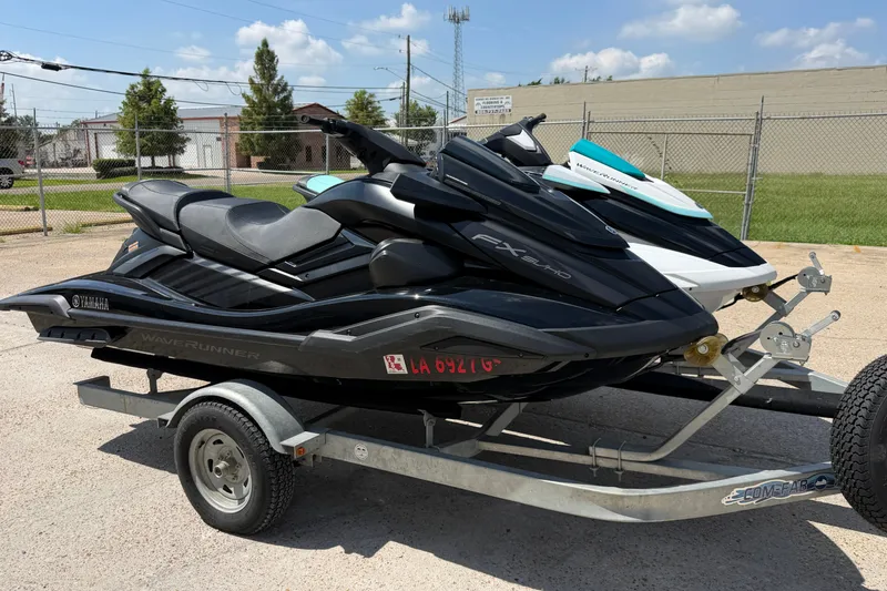 The Image of 2024 Yamaha Waverunner jet skis on a trailer in a parking lot. - 1
