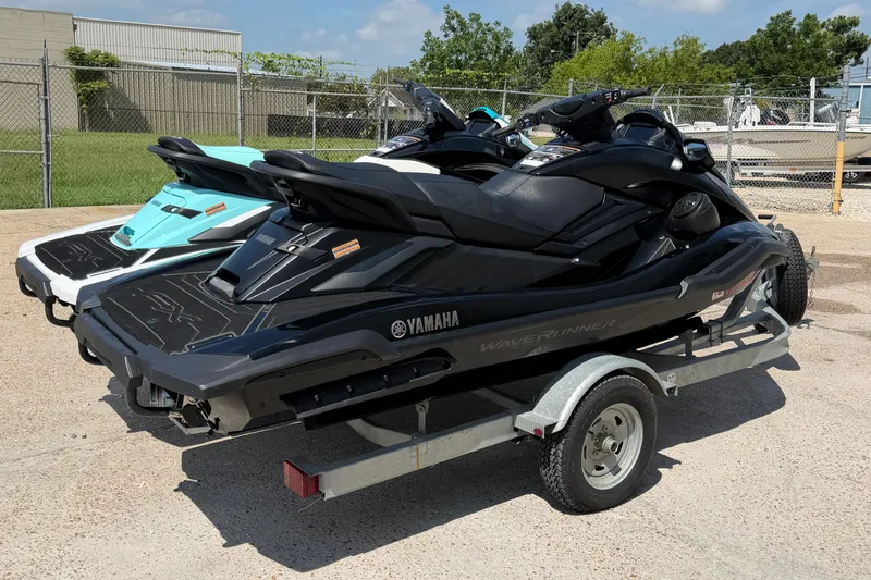 Slide: The Image of 2024 Yamaha Waverunner jet skis on a trailer, parked outdoors. - 2
