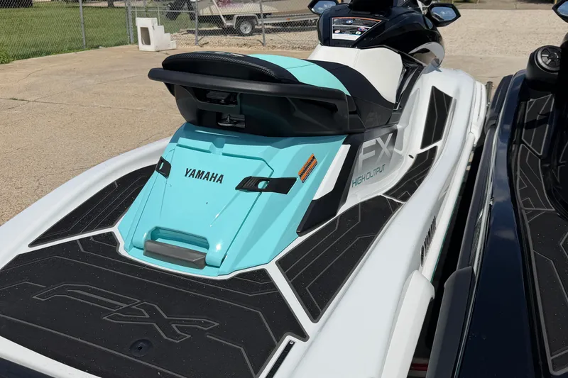Slide: The Image of 2024 Yamaha Waverunner FX High Output in turquoise and black, parked outdoors. - 12