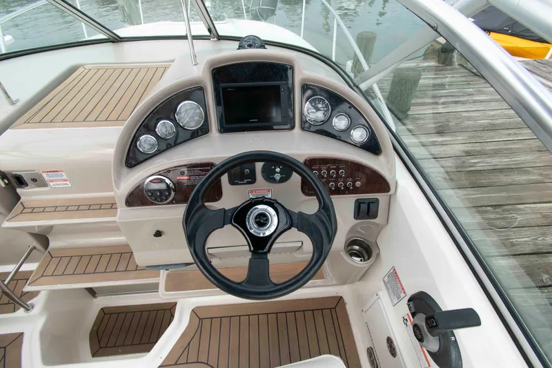 Slide: The Image of 2007 Sea Ray 270 Amberjack helm with steering wheel, gauges, and wood accents. - 7