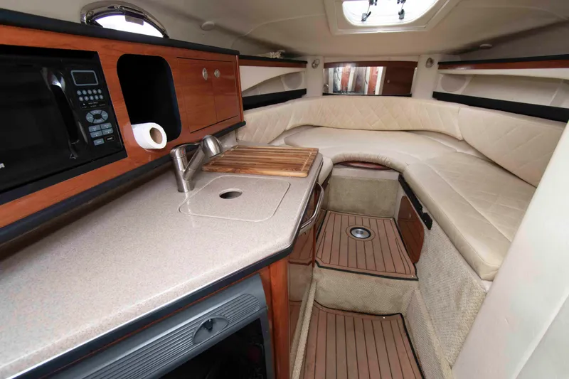 Slide: The Image of Interior of 2007 Sea Ray 270 Amberjack boat with kitchenette and seating area. - 9