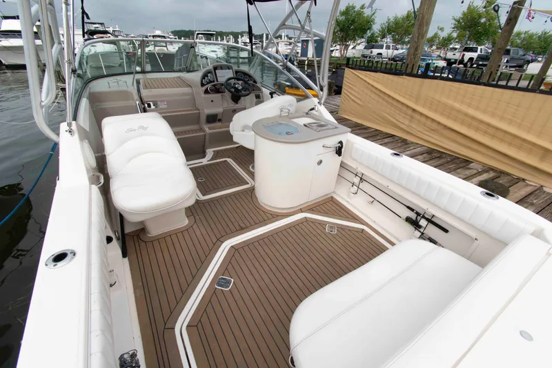 Slide: The Image of 2007 Sea Ray 270 Amberjack boat interior with white seating and wood flooring. - 2