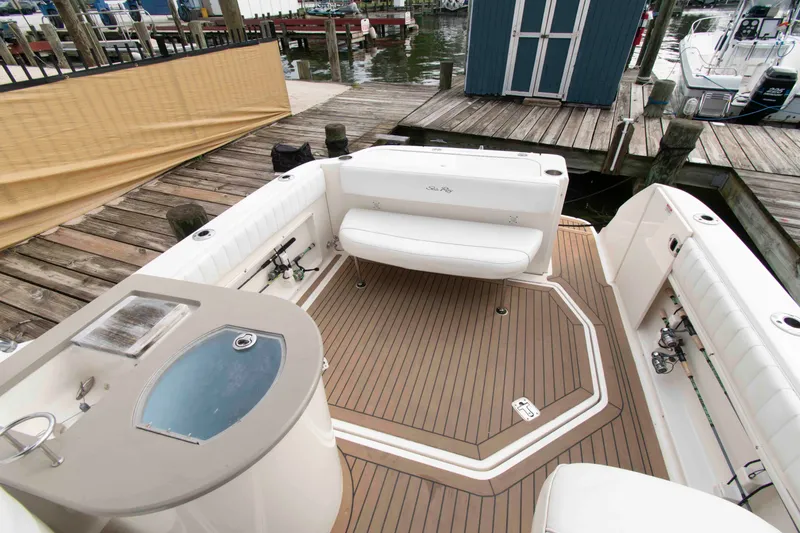 Slide: The Image of 2007 Sea Ray 270 Amberjack boat interior with seating and fishing amenities at a dock. - 8